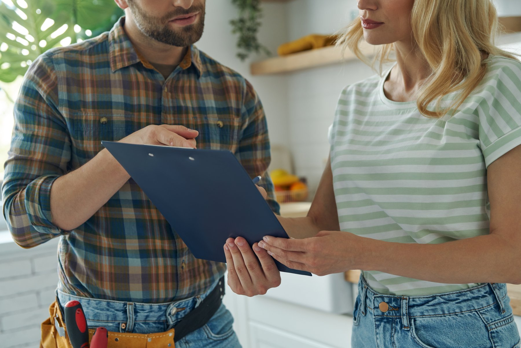 A homeowner and advisor reviewing a plan together in a kitchen